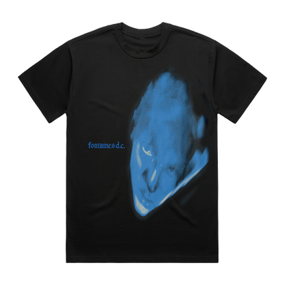 A black short-sleeve t-shirt featuring a large blue graphic print of a distorted face on the front, with the text 'fontaines d.c.'
